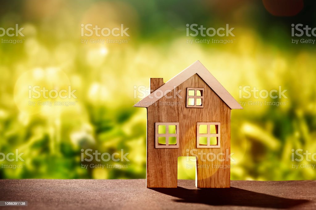Wooden house on stone floor in front of nature background with bokeh